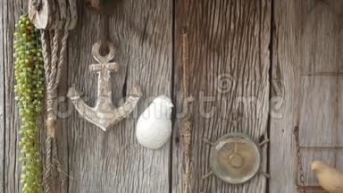 木制墙壁装饰的老式海洋配件，锚，罗盘和绳子。 破旧的木墙和复古的航海